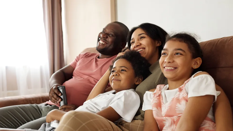 Parents spending time together with their two young children at home.