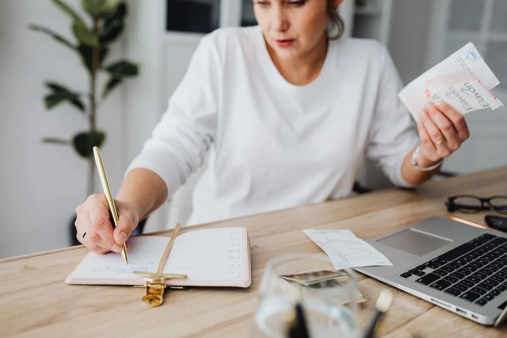 A woman planning at a bright wooden desk